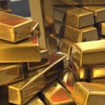 Stacked gold bars representing the density comparison between tungsten, lead, and gold